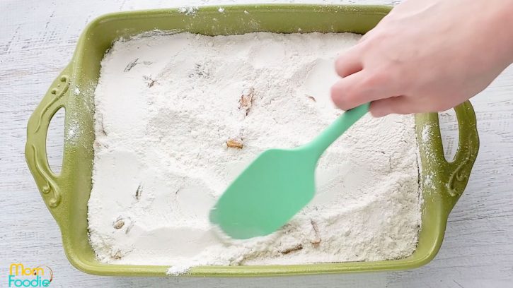 boxed cake mix spread over peaches, making sure to sprinkle cake mix evenly.