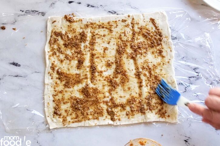 Basting the pastry sheet with the mustard dressing. Spread evenly.
