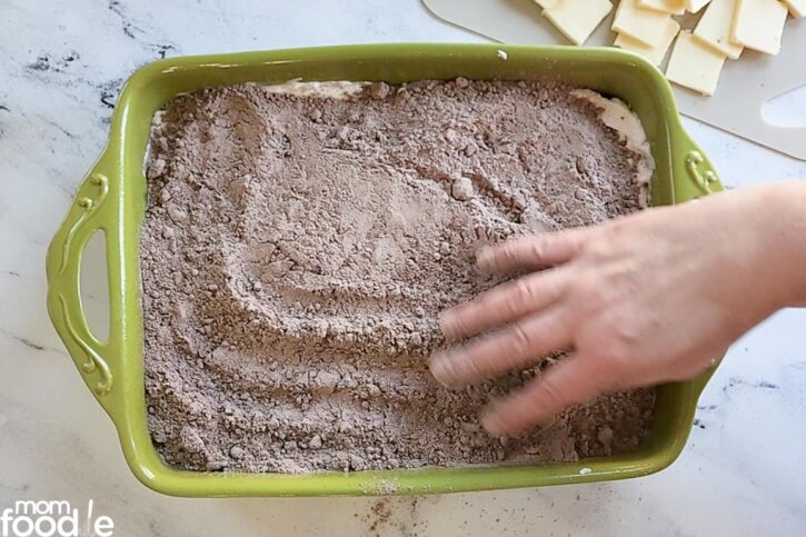 spreading out dry chocolate cake mix in baking pan