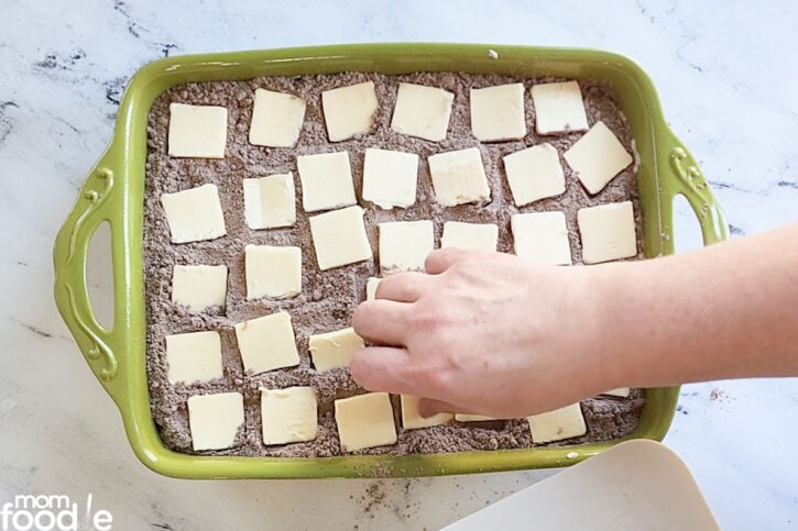 placing butter slices over cake mix