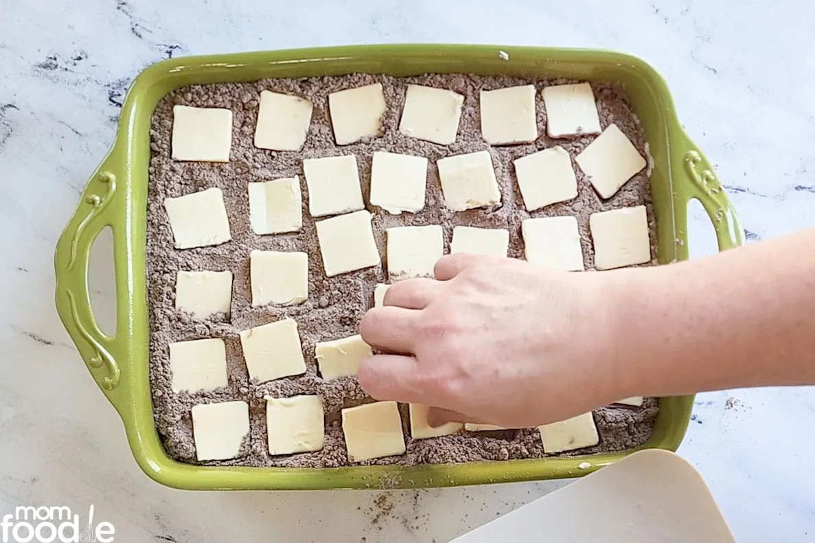 placing butter slices over cake mix