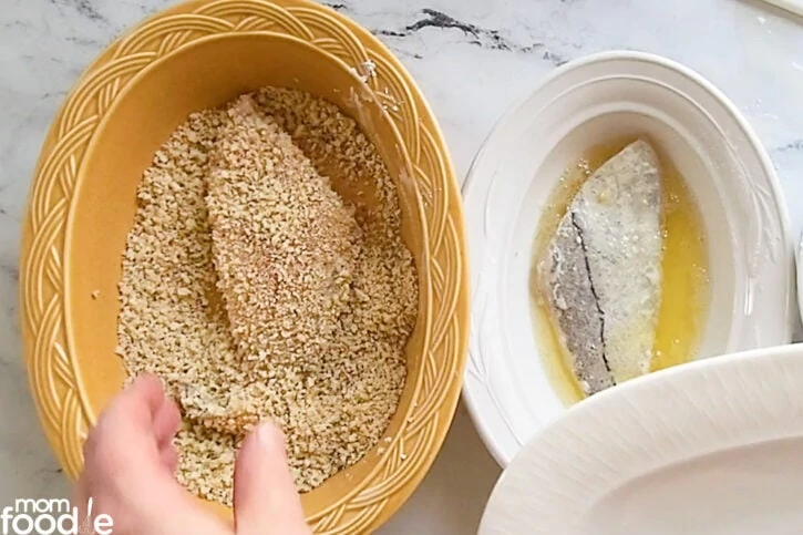 covering fish fillet in breadcrumb mixture