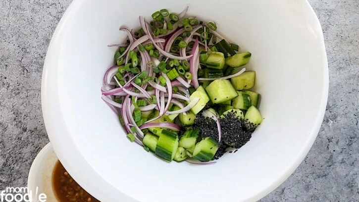 dump cucumbers in large bowl add onion and sesame seeds,