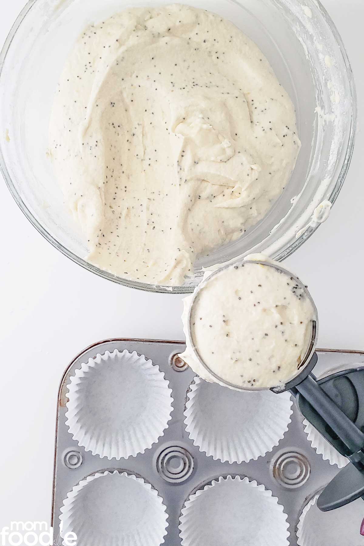 scooping lemon poppy seed muffin batter into cupcake liners