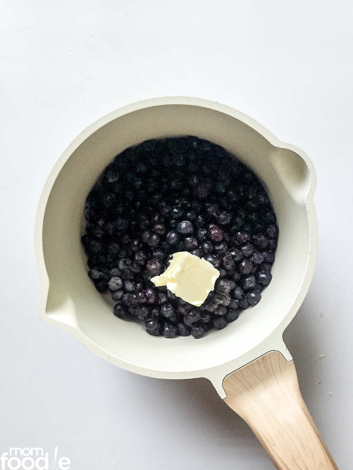 place frozen or fresh blueberries and butter in pan