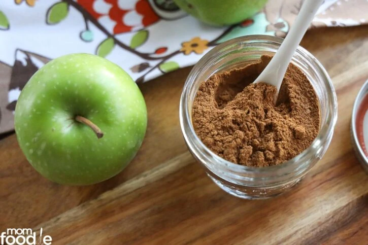 spices in jar with apple on side.