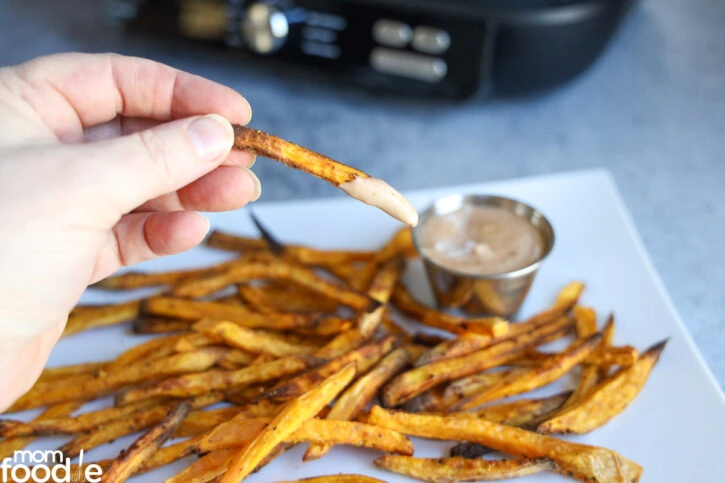 Dunking homemade sweet potato fries into Yum Yum sauce.