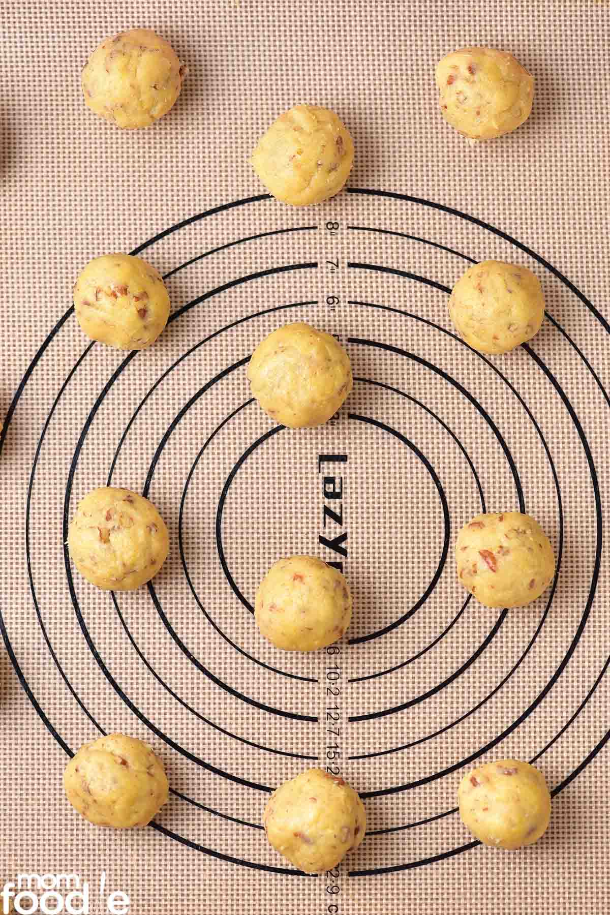 Chilled snowball cookie dough rolled into balls and placed on prepared baking sheet