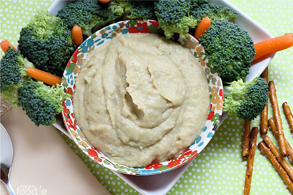 Artichoke white bean dip in bowl with veggies