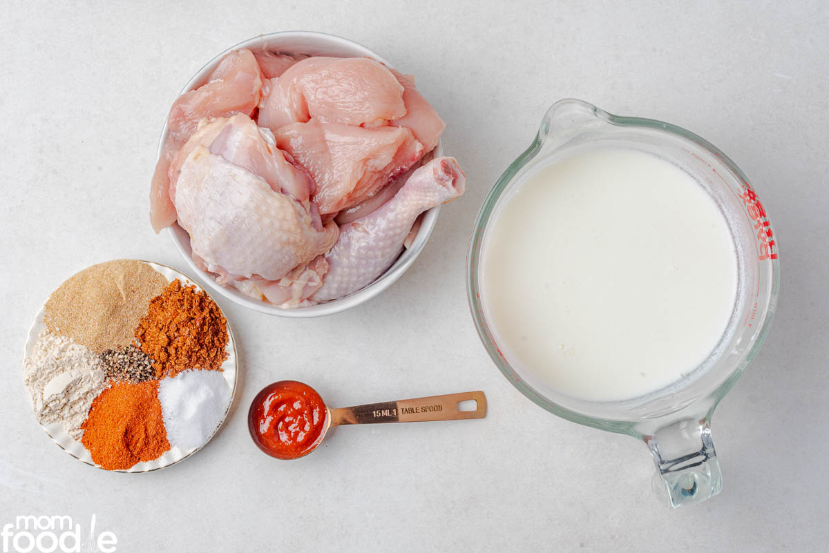 pieces of bone-in chicken with ingredients for the buttermilk marinade