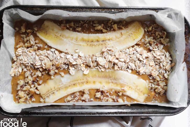 banana slices and oats on top of the banana bread with dates