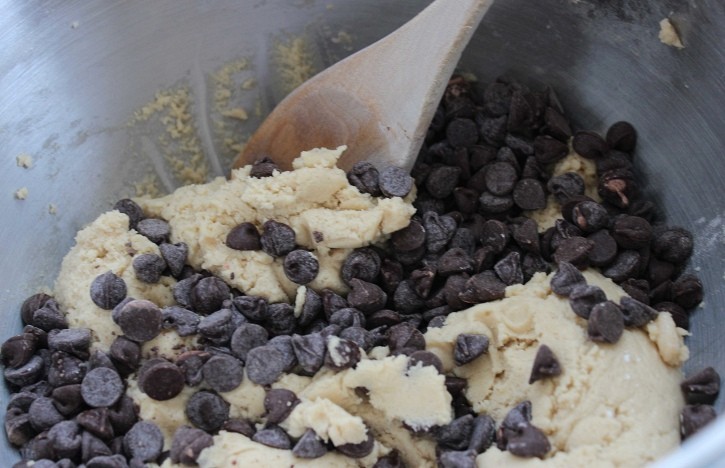Chocolate Chip Cookie cookie dough being mixed in stainless steel bowl.