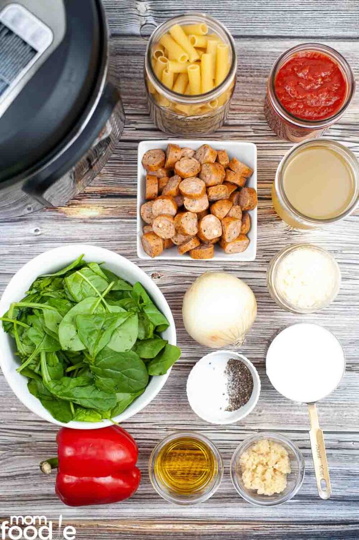 Ingredients for cheesy kielbasa Pasta on wood surface.