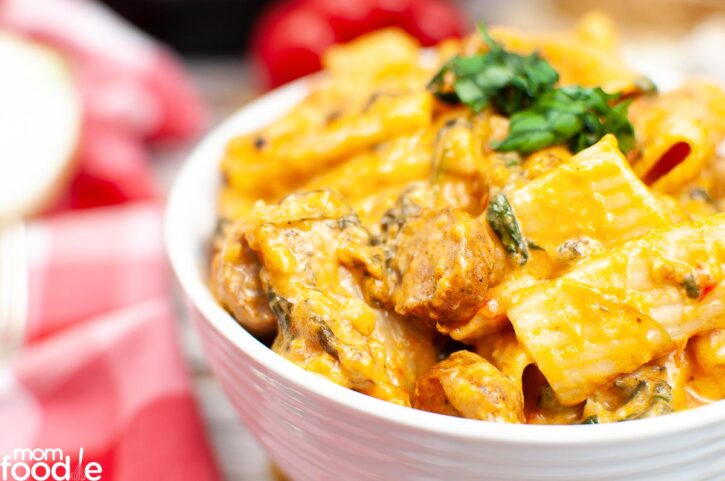 Creamy pasta with kielbasa sausage in bowl.