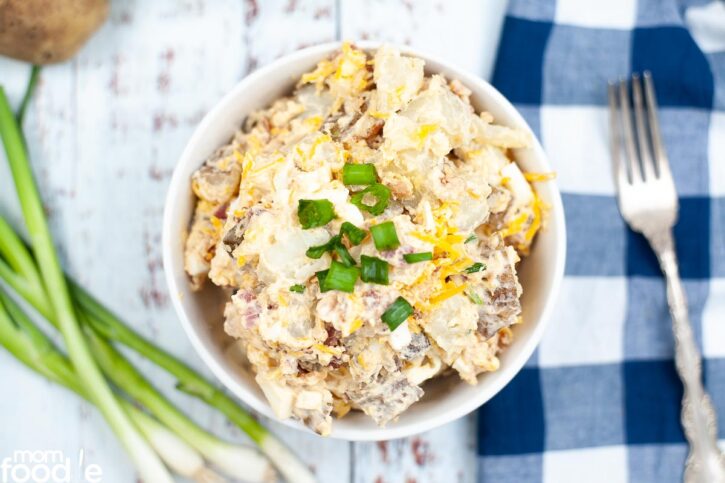 Instant Pot Loaded Potato Salad served in white bowl with chopped green onion.
