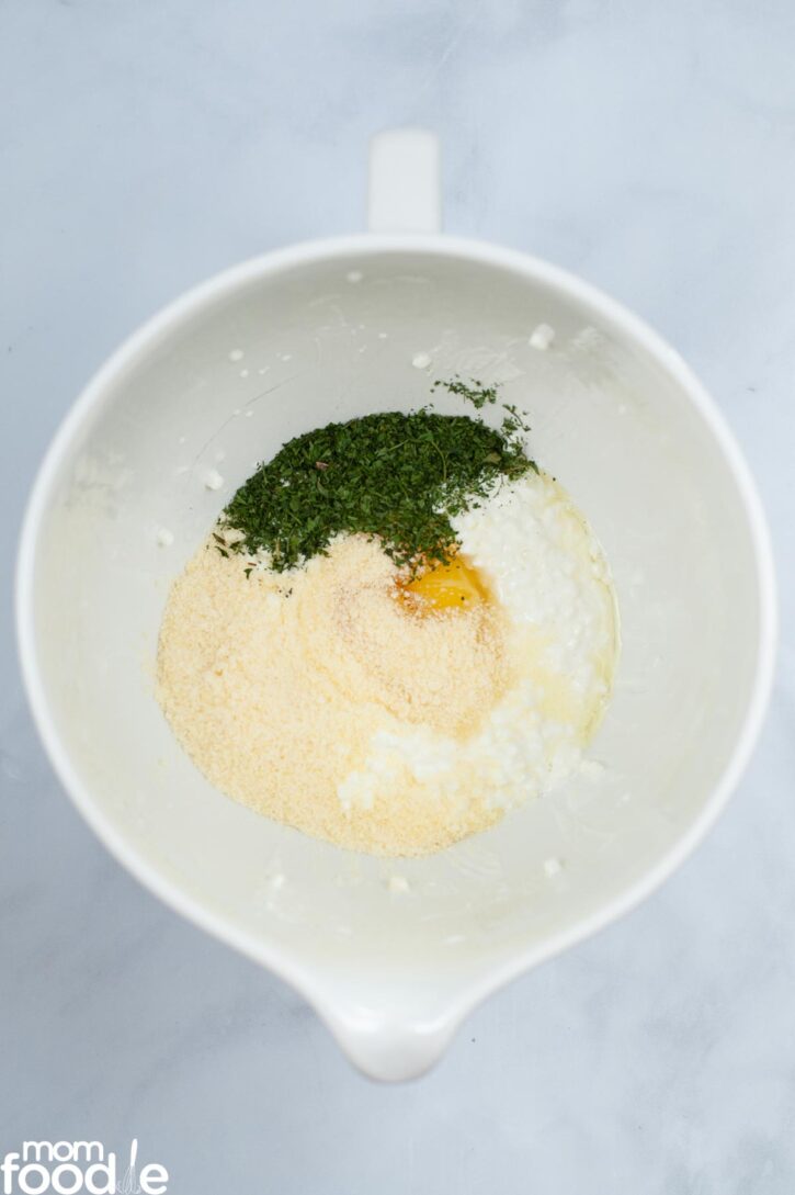 Ricotta cheese, Parmesan, eggs and 1 tablespoon of the parsley in medium bowl before mixing.