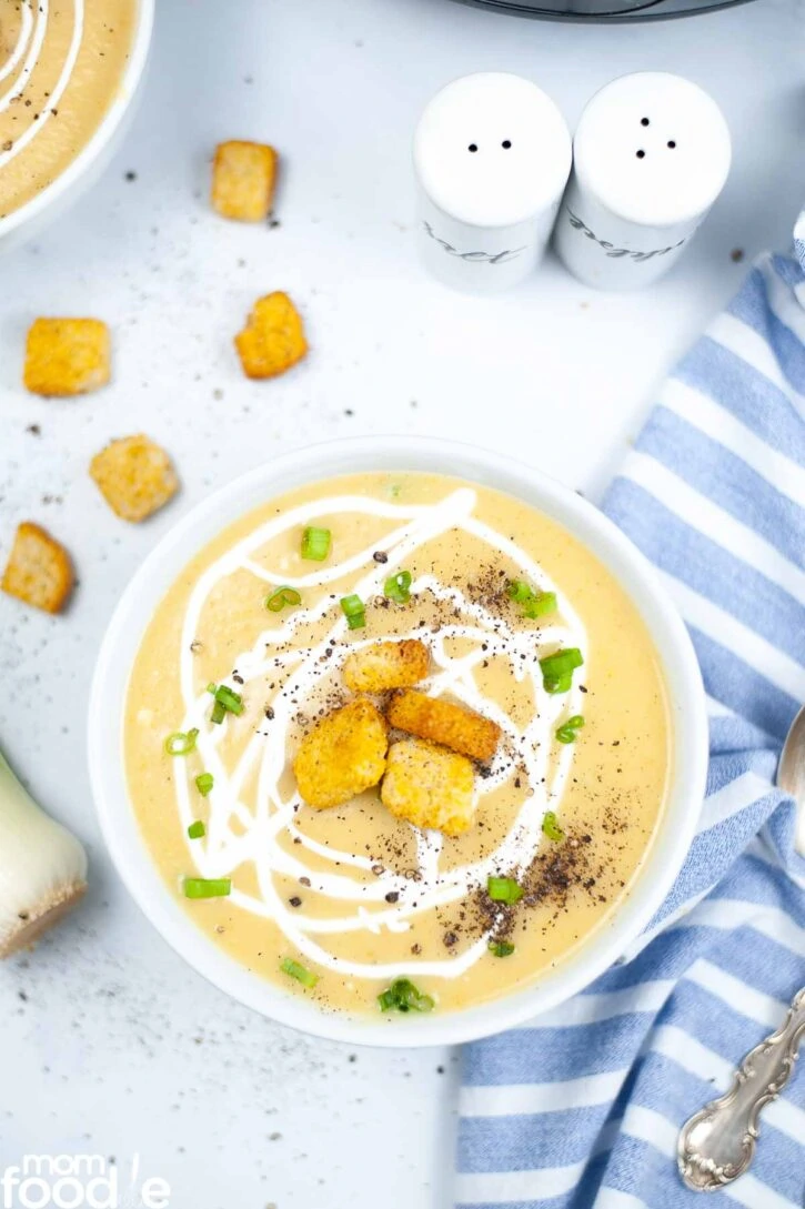 potato leek soup served in white bowl with croutons.