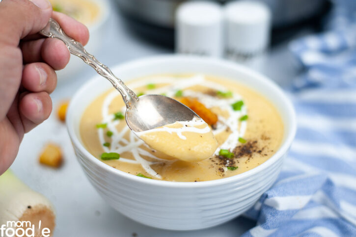 Leek soup scooped up in spoon.