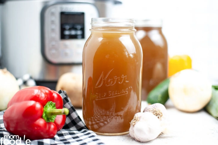 instant pot vegetable stock in glass jars for storage.