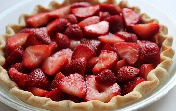  layering sliced strawberries in crust