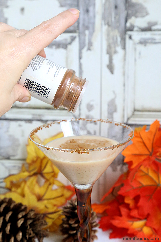 sprinkling pumpkin pie spice on top of martini 