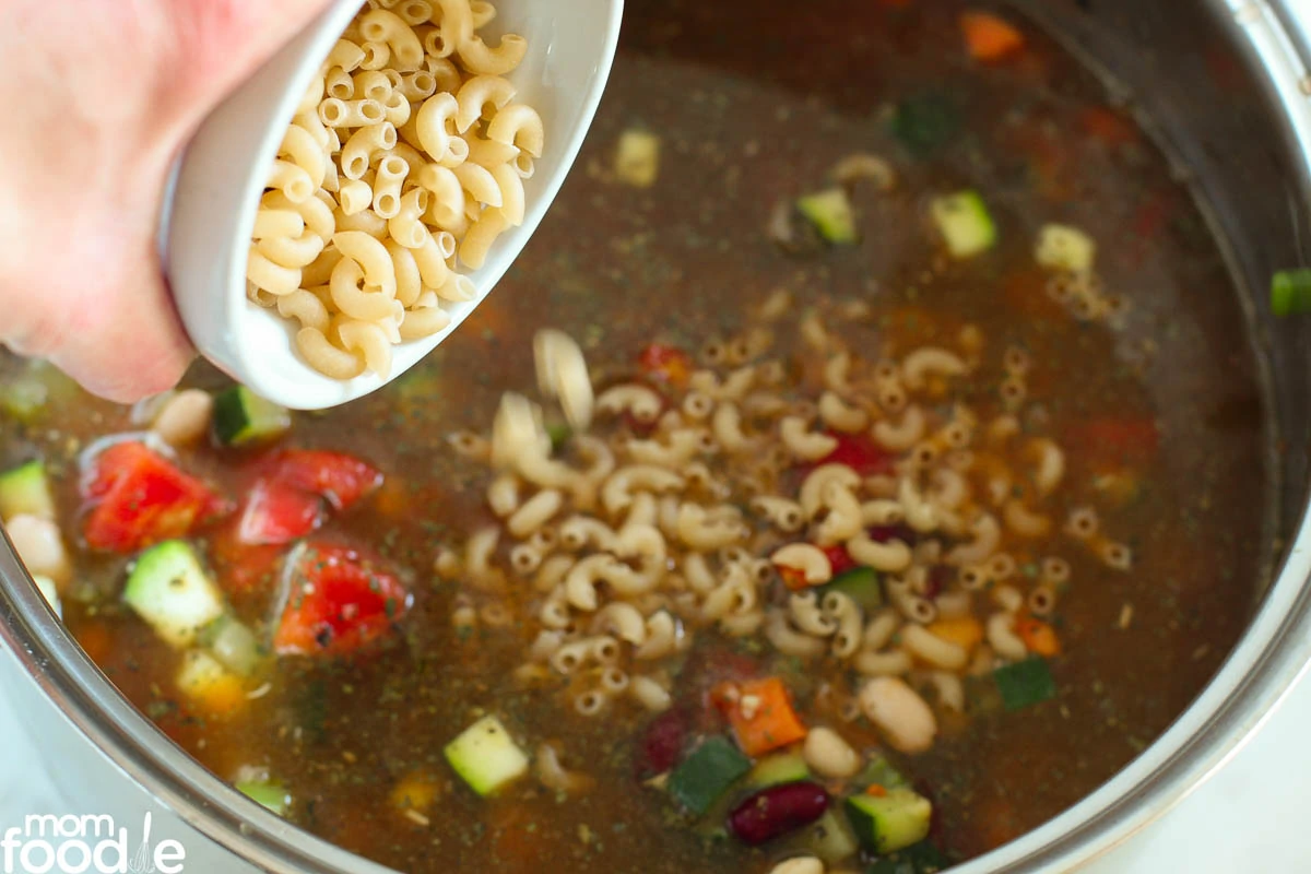 adding dry pasta to pot.