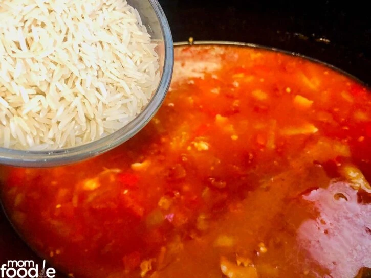 Adding rice to the sauce in crock pot.