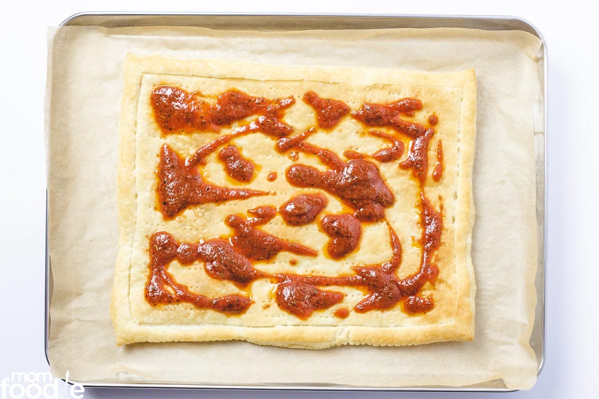 spoon on the pizza sauce