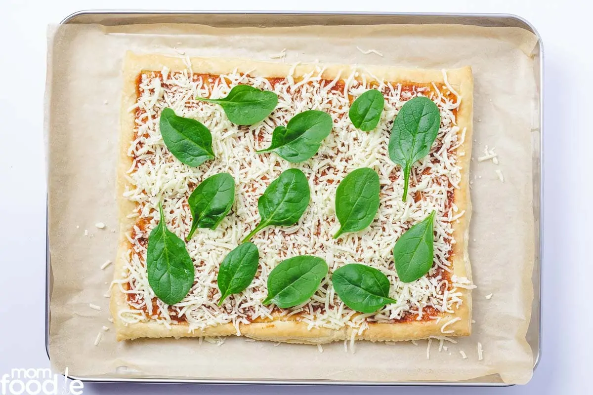 place baby spinach over cheese