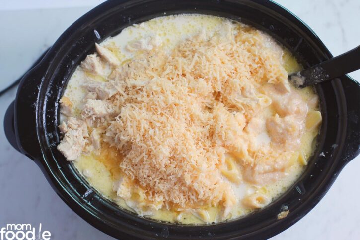 cover cooked pasta with cheese and add chicken to the crock pot
