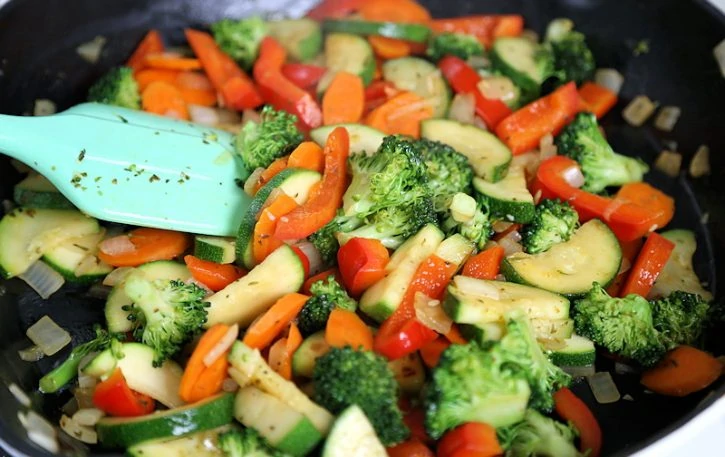 sauteed vegetable stir fry in pan, carrot, broccoli, squash and sweet bell pepper.