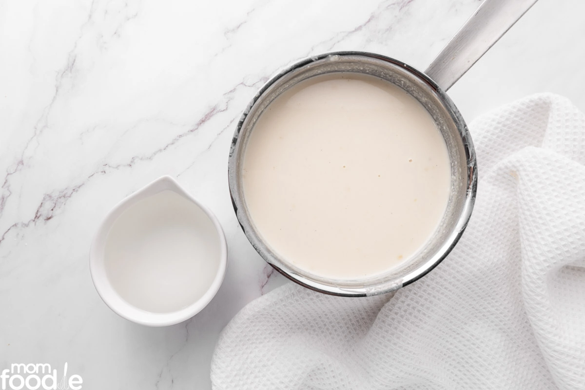 Adding rum to the Coquito cocktail.