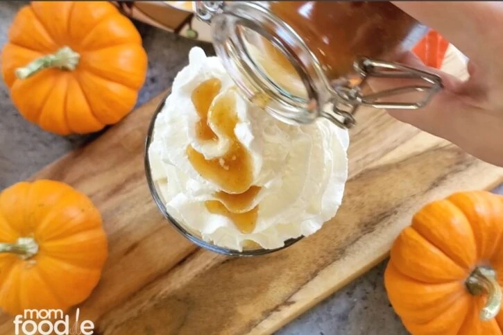 Making a copycat starbucks pumpkin spice latte coffee, the sauce like syrup sticks nicely to the whipped cream.
