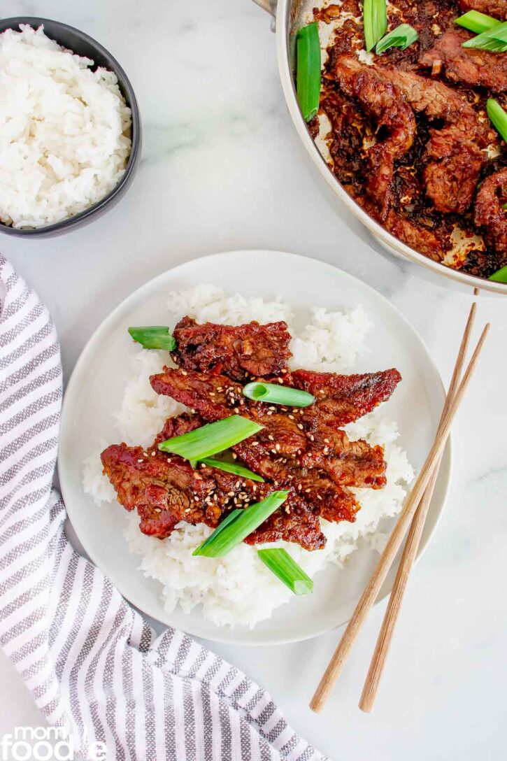 Serving Mongolian Beef, shows plated serving and skillet of beef on background.