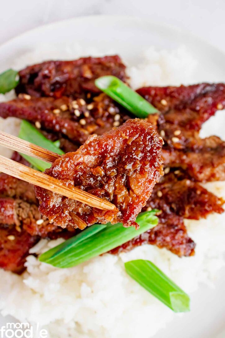 Slice of Mongolian Beef on chopsticks.