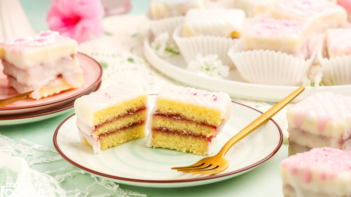 petit four cut in half on plate showing cake and raspberry jam filling