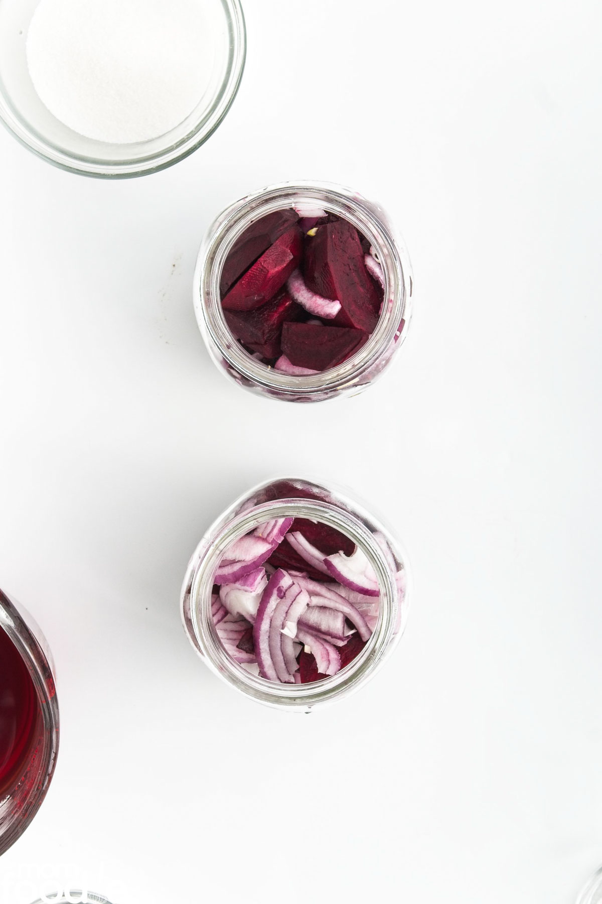 slices of beets with onions packed  into canning jars.