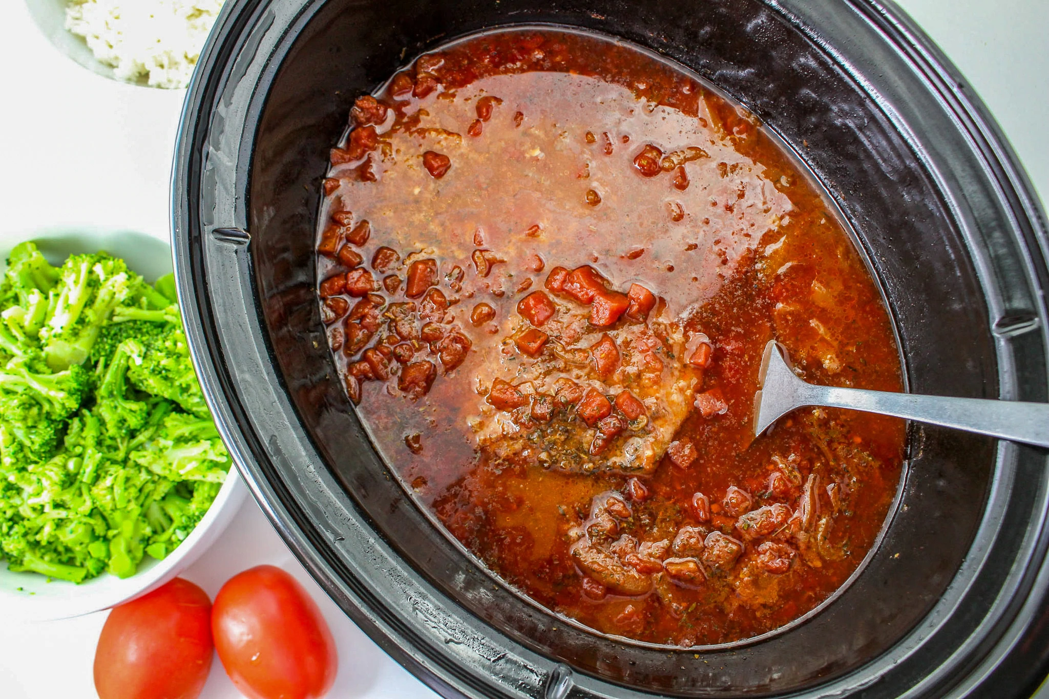 fully cooked cube steak in crock pot with tomato gravy mixture