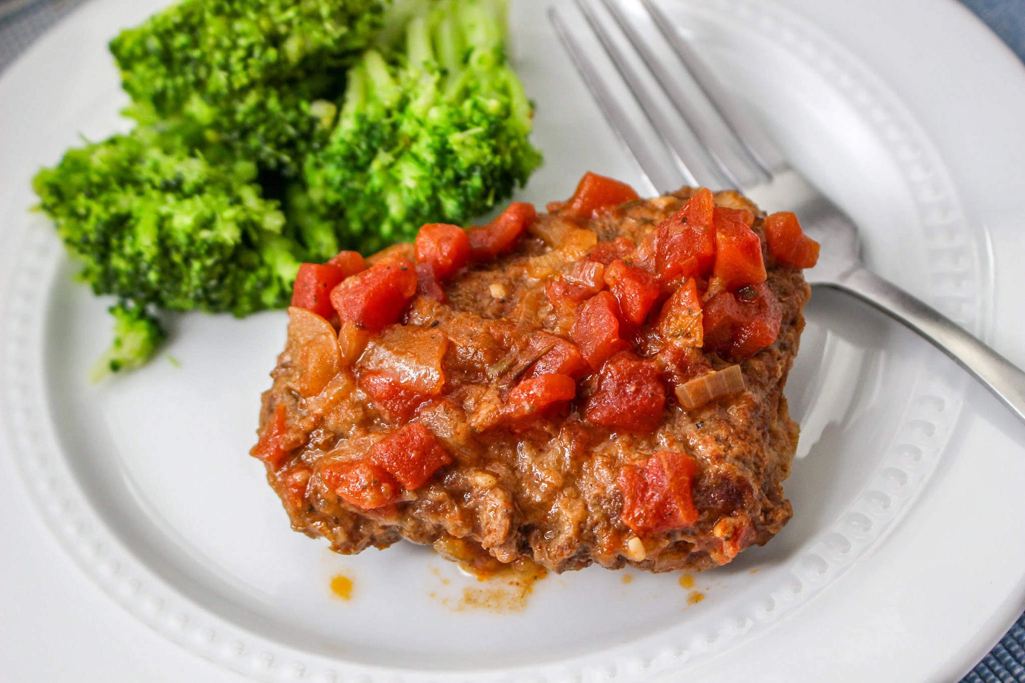 cubed steak with tomatoes and steamed broccoli
