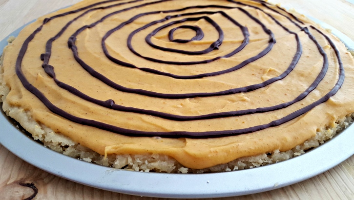 Spider web cookie pizza frosting the cookie and setting up web