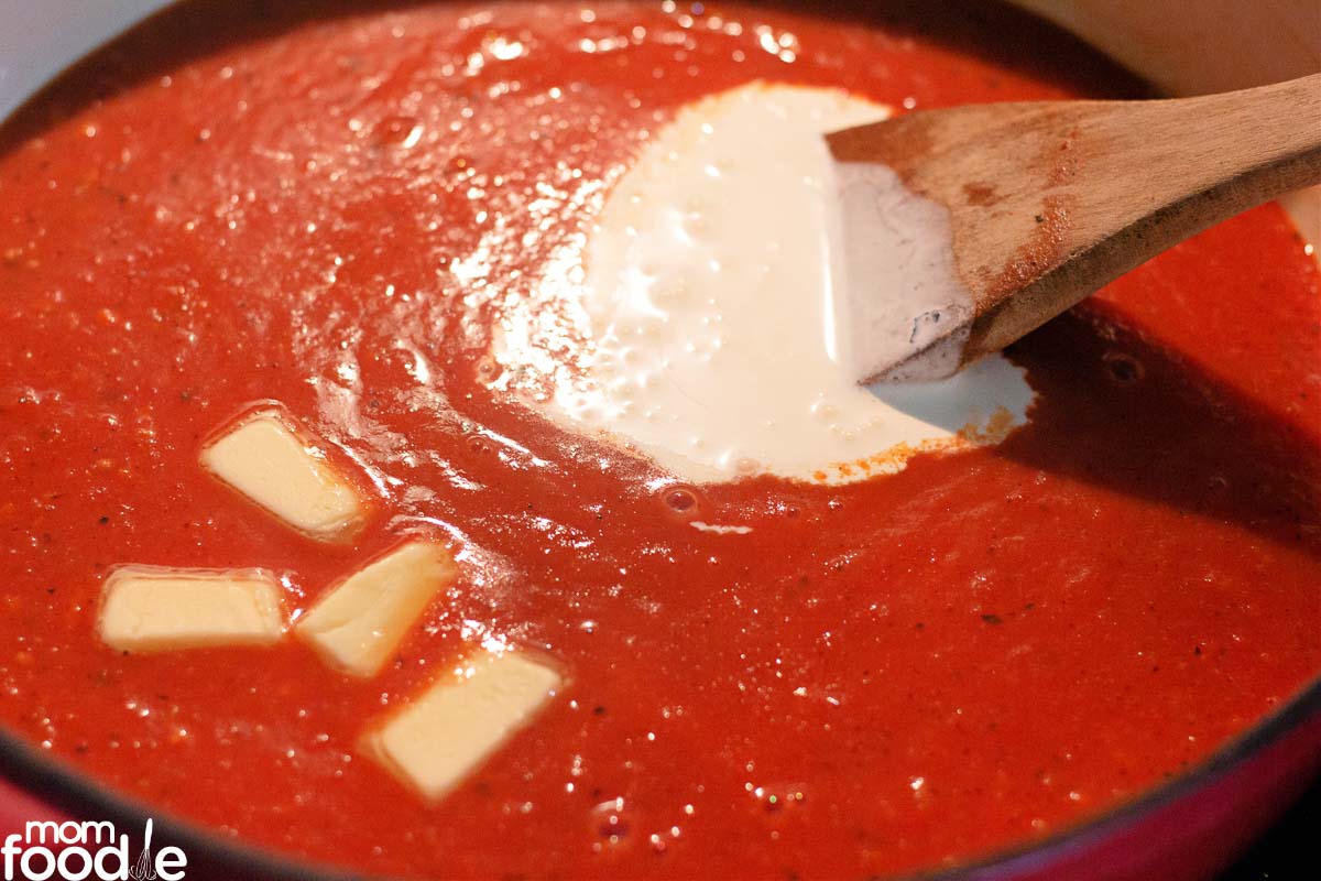 stirring cream into the tomato soup