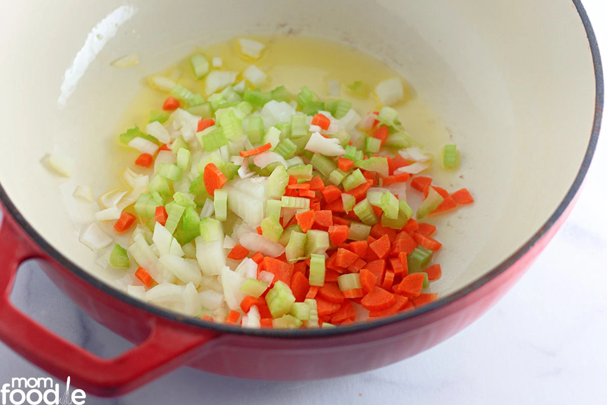 carrots, onion and celery in pot with oil