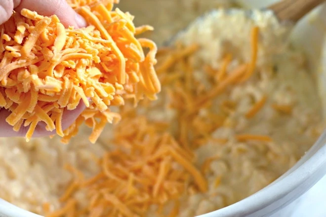 adding cheddar to the casserole.