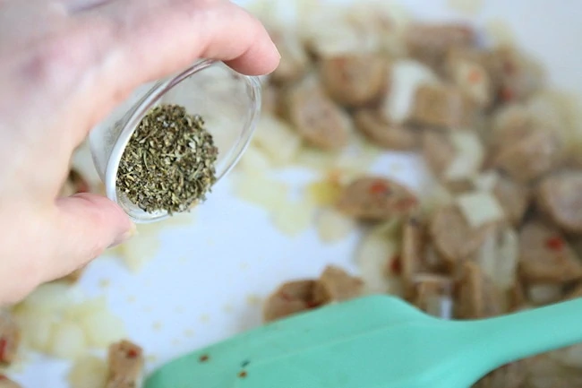 adding herbs to skillet.