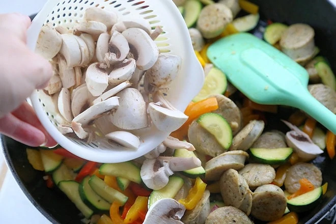 adding mushrooms to the chicken sausage mixture.