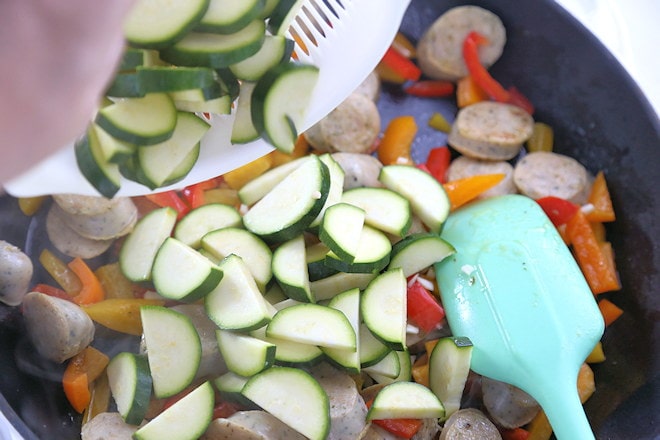 adding zucchini and garlic to the pan.