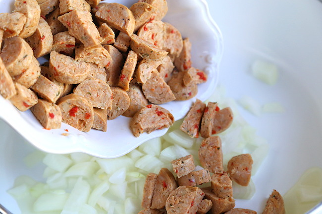 chicken sausage for soup being tossed into pan with onions.