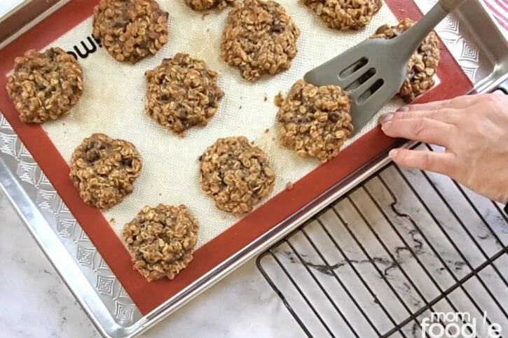 Transferring cookies from prepared cookie sheet to wire rack to finish cooling.