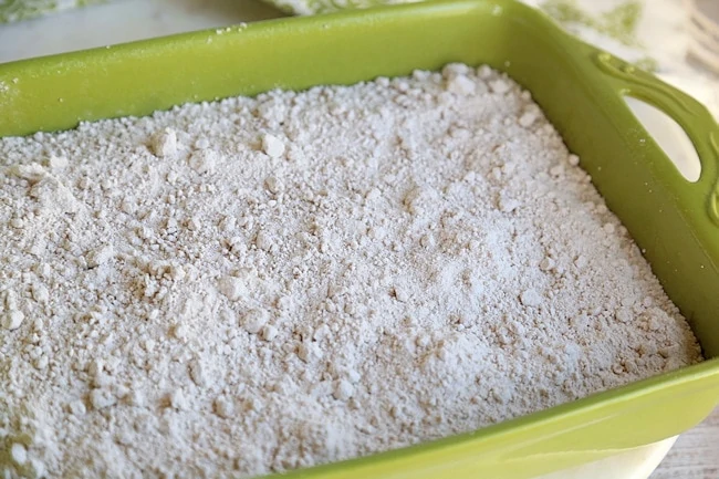 Sprinkle box yellow cake mix evenly on top of the pan of pumpkin mixture.