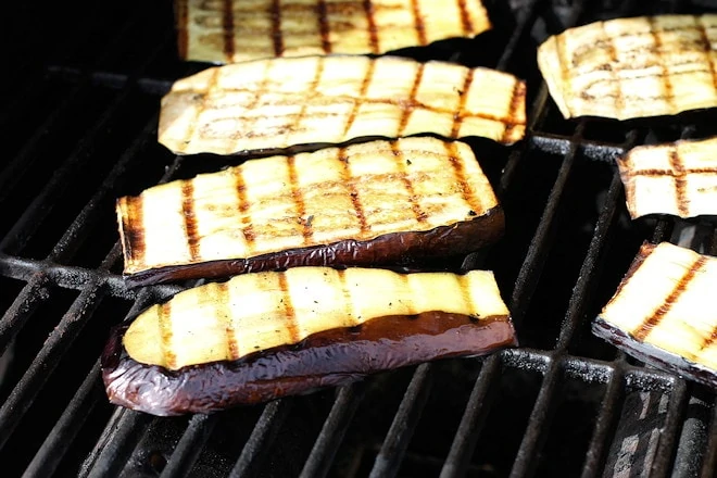 Eggplant parmesan grilled with char marks, still cooking.